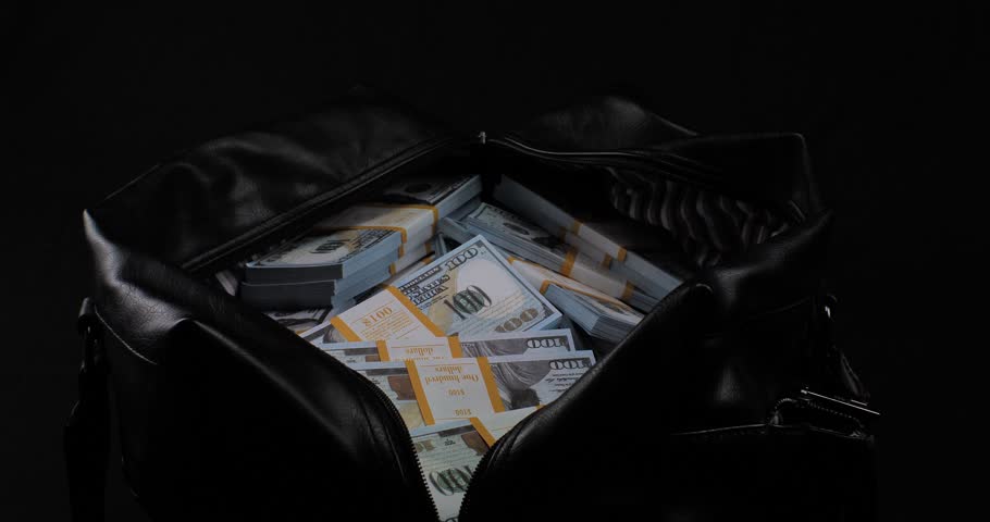 On a black background, I put stacks of hundred dollar bills into a large bag. A man in business clothes puts stacks of dollars in a bag. Accumulated money in large bags on a black background. Royalty-Free Stock Footage #3471714197