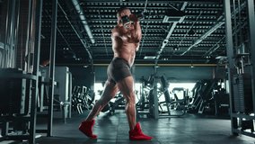 A man with well-defined muscles does dumbbell squats, demonstrating power and technique in his workout routine at a well-equipped gym. Camera 8K RAW.  - Powered by Shutterstock - Get 15% off with code: PIKWIZARD15