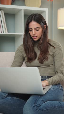 Vertical. Woman having a finance problem using a laptop overwhelmed with the debts. Sad, tired and frustrated female unhappy with her job having a work trouble. Desperate lady with stress and headache