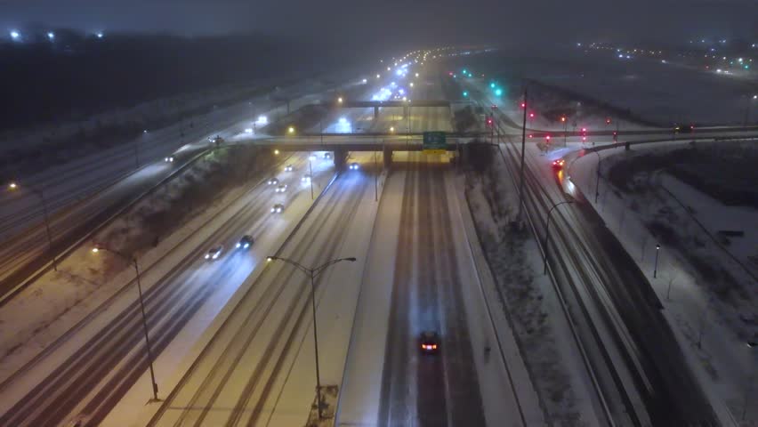 traffic slowing on snow-packed icy roads on a busy section of highway during the winter