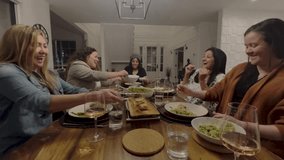 A group of friends having a dinner party laughing with joy at the dinner table while they eat healthy food.
 - Powered by Shutterstock - Get 15% off with code: PIKWIZARD15