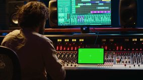 Audio technician working with music recording software and editing tunes, mixing console and control panel board in post production studio. Producer operating technical equipment. Camera A. - Powered by Shutterstock - Get 15% off with code: PIKWIZARD15