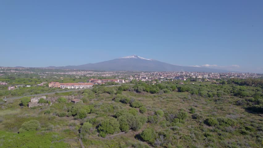 Aerial orbit over the village under the Etna Volcano in summer