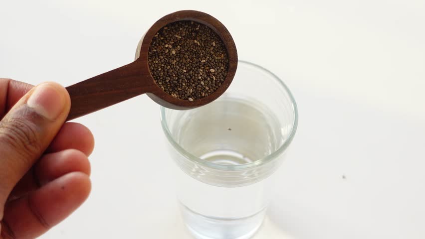 chia seeds i pouring n a glass of water 
