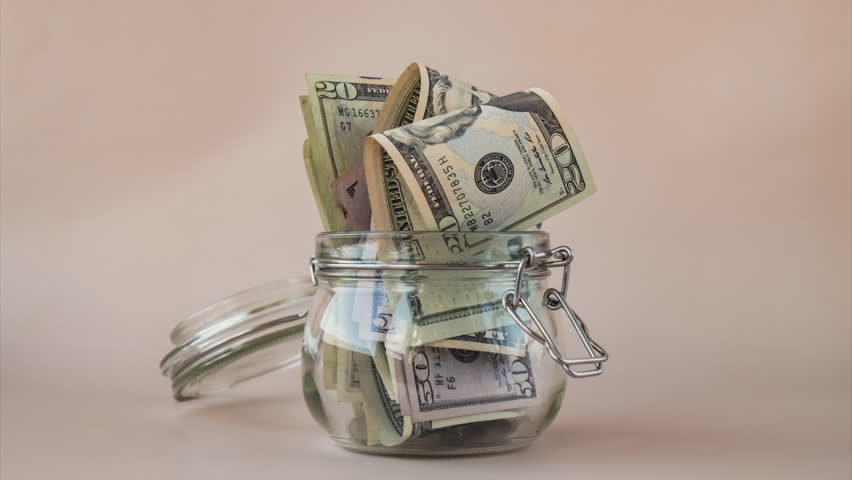 Stop motion of Dollar banknote saving money in glass jar. Consumption and economy Collecting money. Tips. Business, finance, saving, banking and people concept