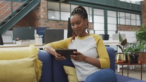 Animation of network of connections with icons over biracial businesswoman using tablet in office. Business and digital interface concept digitally generated video. - Powered by Shutterstock - Get 15% off with code: PIKWIZARD15