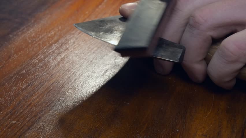Cut edge on small Viking hatchet axe is sharpened using a whetstone Royalty-Free Stock Footage #3472075449