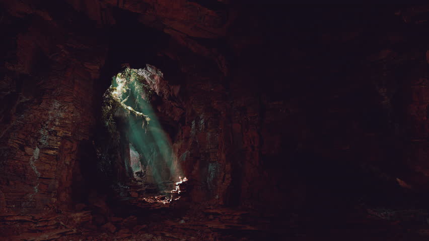 A mesmerizing green light shining through the entrance of a mystical cave Royalty-Free Stock Footage #3472105363
