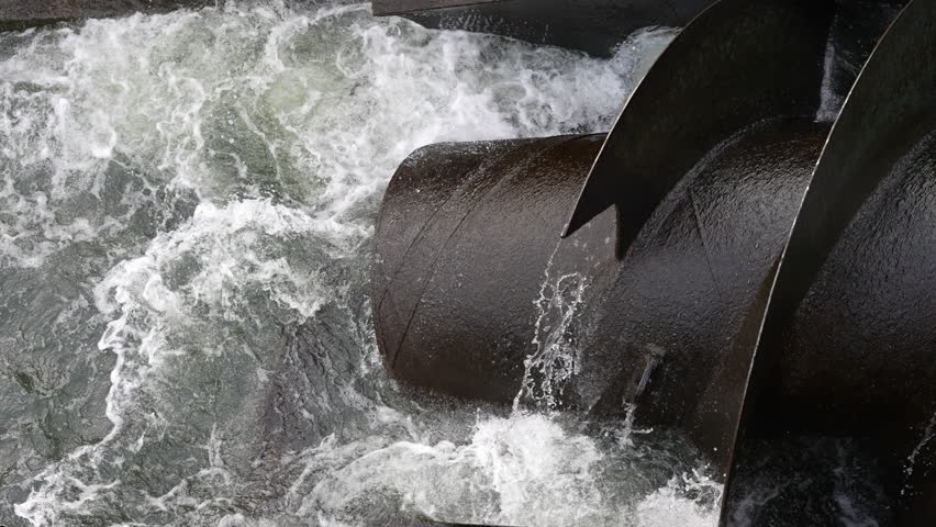 Powerfull metal hydro water turbine screw on river. This spiral is generating clean renewable energy electricity. Nothing but a hydroelectric. SLOWMO 100FPS
