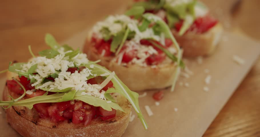 Traditional italian breakfast brunch dish at a restaurant, Healthy food and dieting concept. Healthy, vegan food. Delicious bruschetta sourdough toast with cherry tomatoes, cheese and arugula. Royalty-Free Stock Footage #3472179127