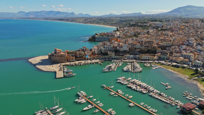 Aerial shot of Castellammare del Golfo, Sicily, Italy. Marina with yachts, old town and mountains in the background in Castellammare del Golfo town, Trapani in Sicily Royalty-Free Stock Footage #3472204307