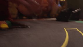 The dealer lays out the cards on the poker table. Long shutter speed , 6 fps