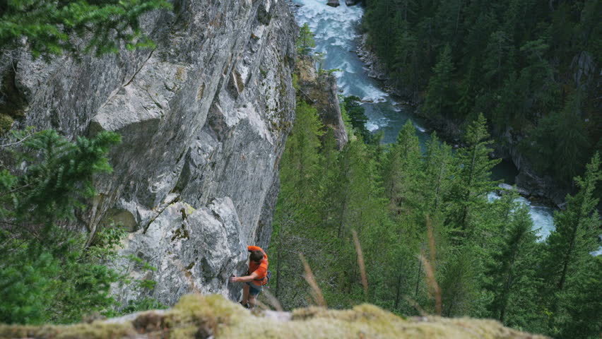 Confident Caucasian American male rock climber using mountain climbing equipment achieving expedition success in Squamish Valley Canada RED WEAPON
