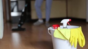 4k video footage detergents in a bucket on the floor and woman cleaning her home in the background