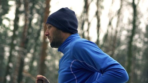 Lone runner in wintry wood, slow motion shot at 240fps
