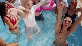 Boyfriends and girlfriends enjoy summer weather at pool party in luxury club. Men and women smile, wave, dive and swim in turquoise clear water. Noisy celebration on hot vacation with friends. - Powered by Shutterstock - Get 15% off with code: PIKWIZARD15