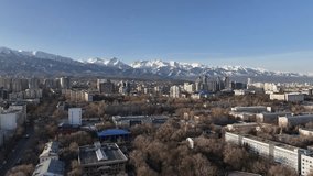 View from a quadcopter of the south-eastern part of the Kazakh city of Almaty against the backdrop of a mountain range on a sunny spring day