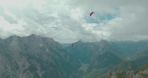 drone video of paragliders flying among the mountains