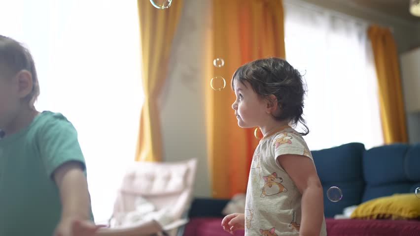baby group playing bubbles indoors. happy family kid dream concept. baby group catching soap bubbles with their hands. group of children playing with soap bubbles having fun