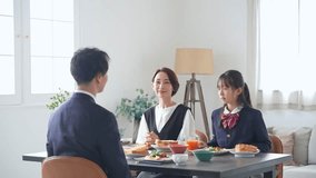 A family of an Asian girl and her parents sit around the dining table and enjoy a meal. - Powered by Shutterstock - Get 15% off with code: PIKWIZARD15