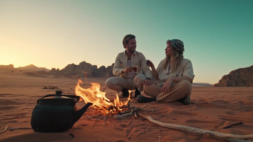 Travelers in Jordan Wadi Rum Sitting and drinking desert tea next to a camp fire Royalty-Free Stock Footage #3472425079