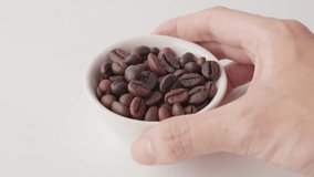 Close-up of hand holding white cup with roasted coffee beans - Powered by Shutterstock - Get 15% off with code: PIKWIZARD15