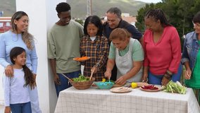 Multi generational people having fun together cooking barbecue at house terrace rooftop - Multiracial friends preparing food with little female child outdoor  - Powered by Shutterstock - Get 15% off with code: PIKWIZARD15