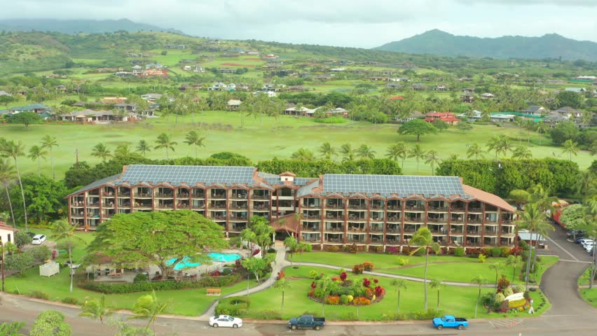 Hotel resort building solar panels on roof aerial drone view. Sustainable electricity generation on sunny tropical island of Hawaii. Travel industry renewable energy source concept