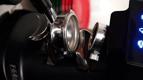 A professional barista worker uses a grinder to grind fresh coffee beans to prepare a hot drink in a coffee shop. close-up. vertical video