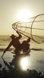 Myanmar travel attraction landmark - Traditional Burmese fishermen with fishing net at Inle lake in Myanmar famous for their distinctive one legged rowing style. Vertical video