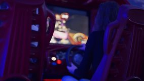 Girl playing racing simulator game in theme park.