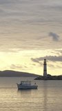 Seascape at sunset. Lighthouse on the coast. Seaside town of Turgutreis and spectacular sunset. Vertical video for social media.