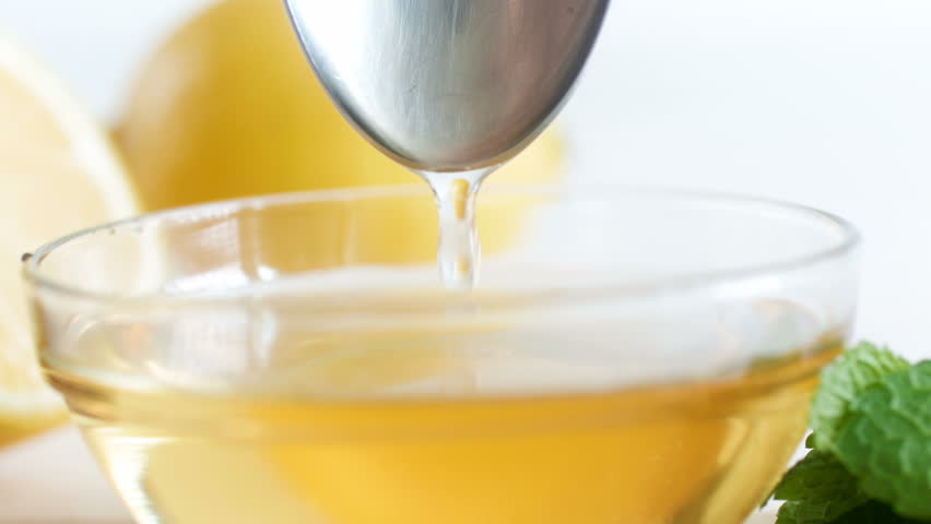 Macro 4k video of honey dripping from metal spoon in glass jar - Powered by Shutterstock - Get 15% off with code: PIKWIZARD15