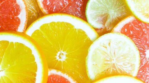 View from top of camera panning along assortment of fresh citrus slices lying on table – Video có sẵn