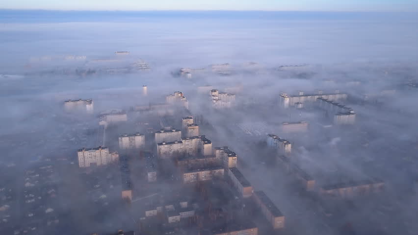 Aerial view of cityscape in smoke and fog.  Beautiful view from bird's eye view to very dense morning fog over city. Smog or fog in the city. Problem of pollution of the environment by smoke and smog. Royalty-Free Stock Footage #34727902