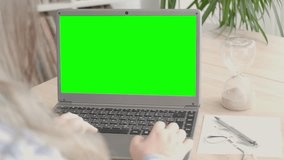 female student business woman looking at empty green blank mockup, holding cup coffee, laptop screen display for advertising, having virtual meeting, remote work, search online, watching webinar
