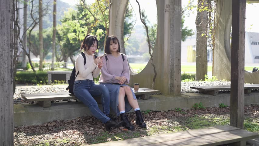 The scene of two Taiwanese female college students in their 20s sitting and talking in Wenshan District, Taipei City, Taiwan