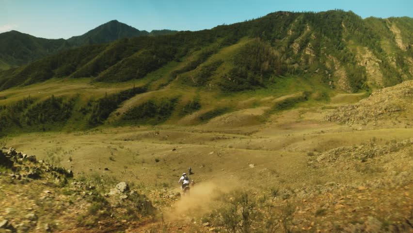 Motocross race against landscape of highlands. Display of agility and speed with riders weaving through natural obstacles in quest for supremacy Royalty-Free Stock Footage #3473017705