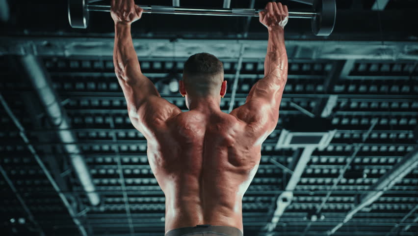 Captured from behind, a dedicated athlete executes an overhead barbell press, showcasing the power and muscular definition of his back and arms. Camera 8K RAW. 