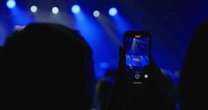 A shot during the performance of artists on the stage of a concert hall, a man holds a phone and takes a video of the performance. Prohibited filming during the performance of a famous artist. 4k