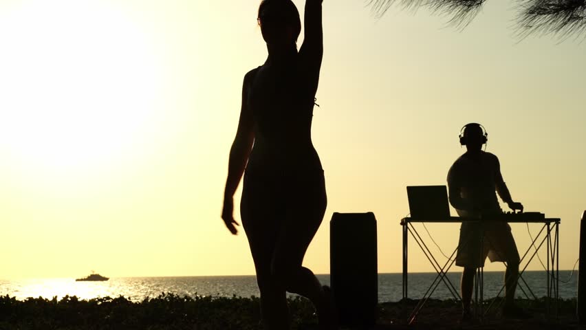 Girl dancing on the beach at sunset