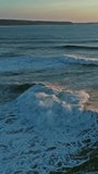 Aerial view on big waves of Atlantic ocean and sunset sky. Vertical video