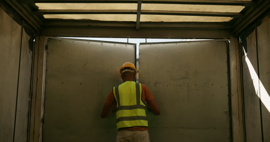 Truck driver, door and open for delivery in logistics, supply chain and distribution from warehouse. Man, worker and courier with vehicle for export, industry or transportation service in Switzerland