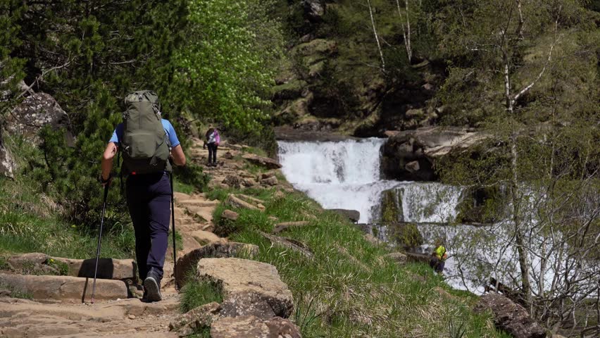 Young male hiker walking down trail in Gradas de Soaso, Ordesa natural park, Spain.