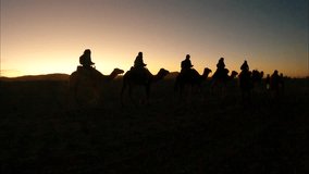 Camel walking through desert in tourists group.  - Powered by Shutterstock - Get 15% off with code: PIKWIZARD15