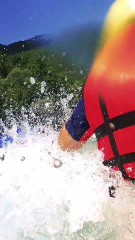 Whitewater Rafting in First Person Point of View. Wave Splashing into Raft Boat. Whitewater Rafting Team in Life Jackets Descending Raging Rapids. Paddling Through White Water. Active Vacations.