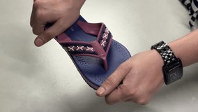 Close-up view 4k stock video footage of new pair of soft and flexible eva slippers in hands of woman