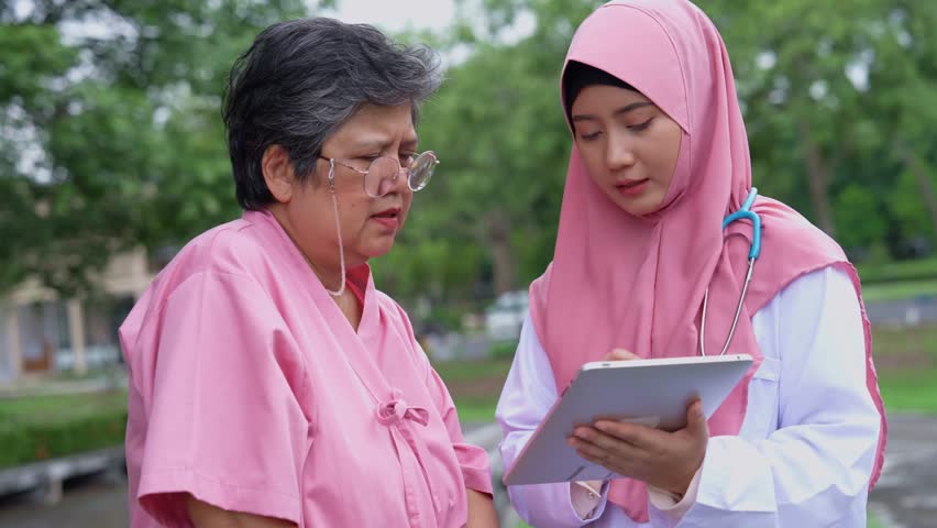Muslim careful caregivers or doctors hold the tablet to Explain guidelines and treating disease, physical therapy. Concept of happy retirement with care from a caregiver and senior health insurance. Royalty-Free Stock Footage #3473255051