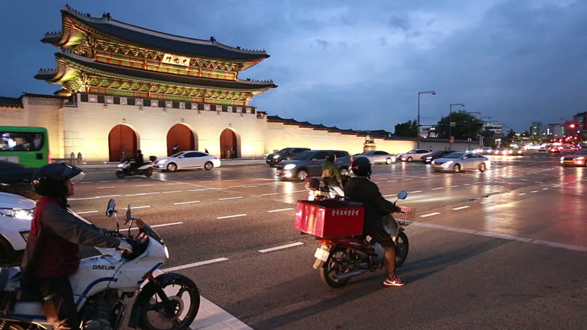 Seoul, South Korea - May 18 2017: Traffic time lapse of cars and motorcycles rushing in front of the Gwanghwamun gate of the Gyeongbokgung Palace in Seoul at night in South Korea capital city. 