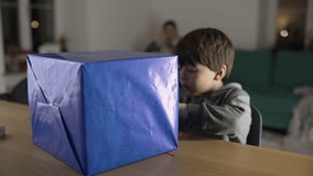Child unwrapping present gift, one small boy tearing paper from package eagerly wanting to open box - Powered by Shutterstock - Get 15% off with code: PIKWIZARD15